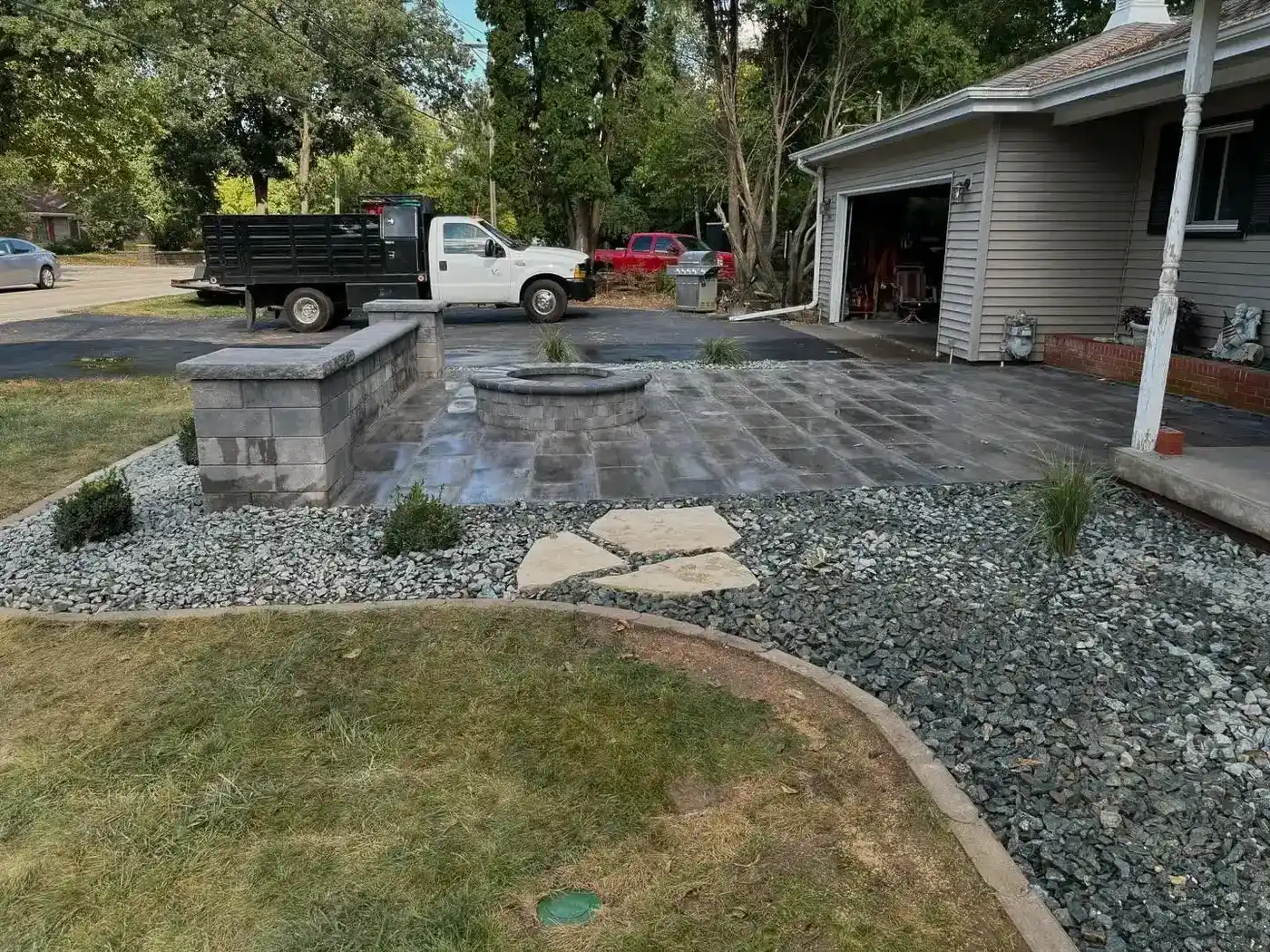 Front yard paver walkway and seat wall with gray rock beds and stepping stones
