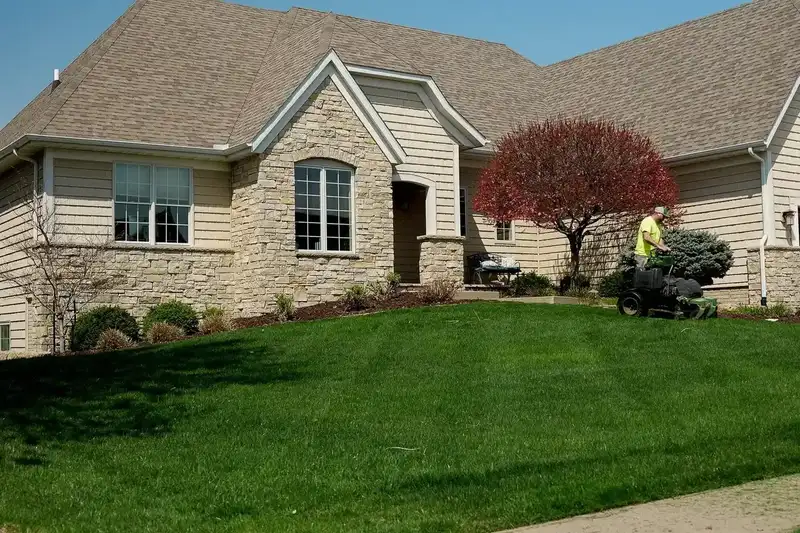 Freshly mowed front lawn with trimmed beds in front of a brick home