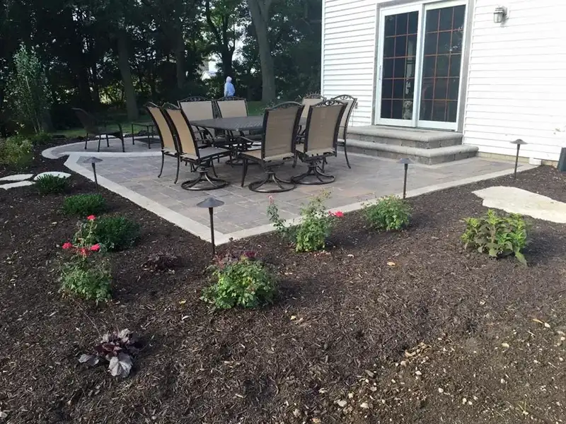 Finished dining patio with table and chairs and planted beds