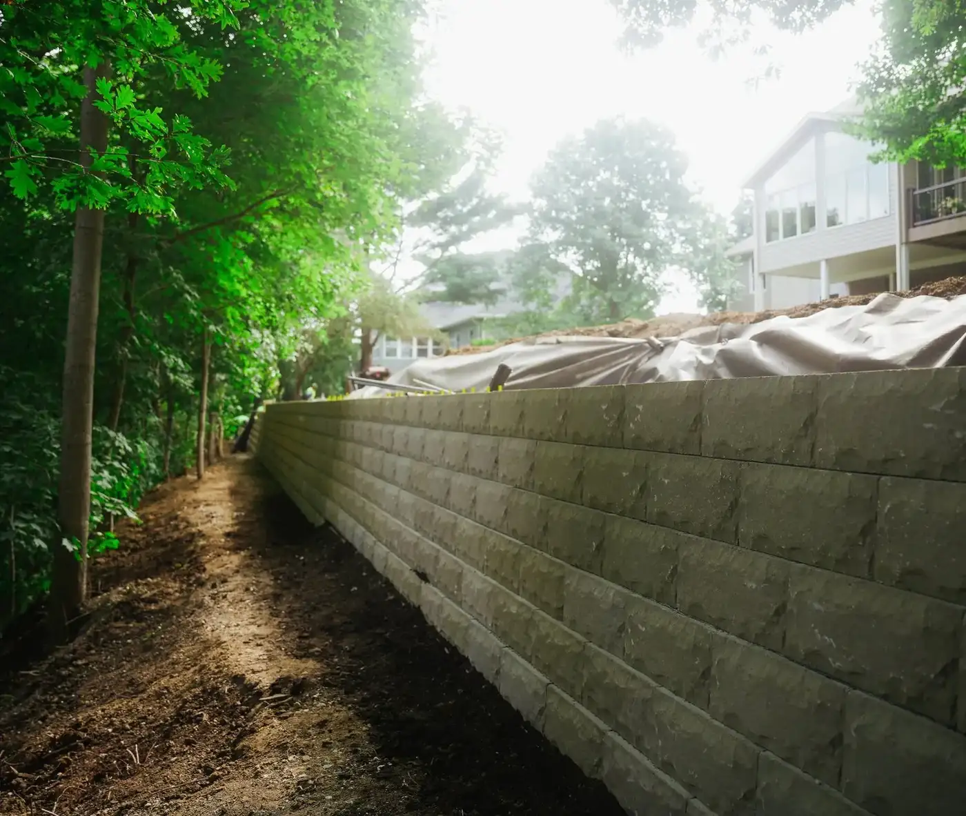 Finished tan block retaining wall with caps along a slope