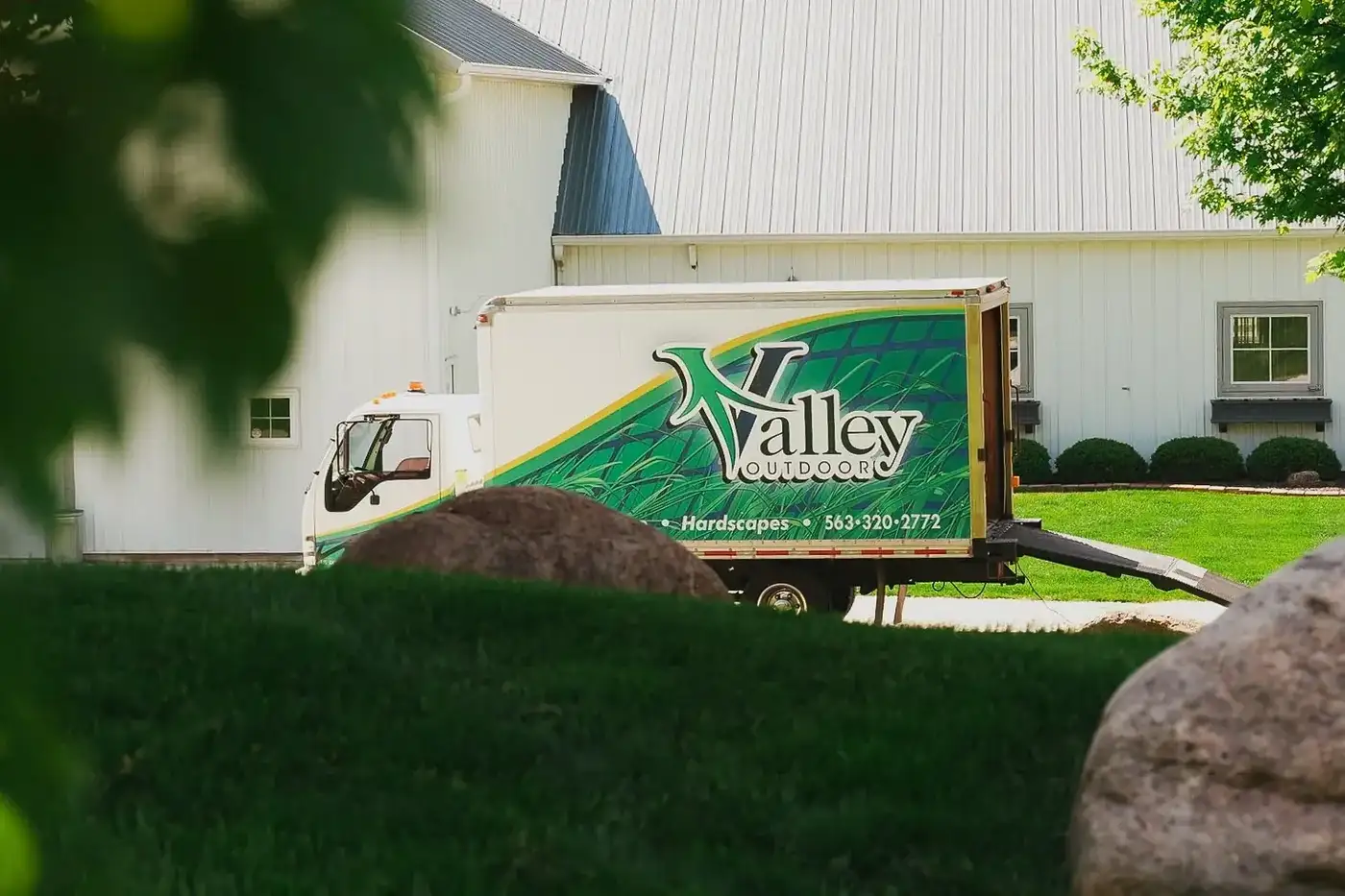 White Valley Outdoor box truck with green and blue graphics parked on a lawn